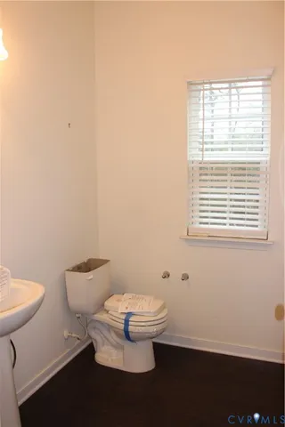 a bathroom with a toilet a sink and a window