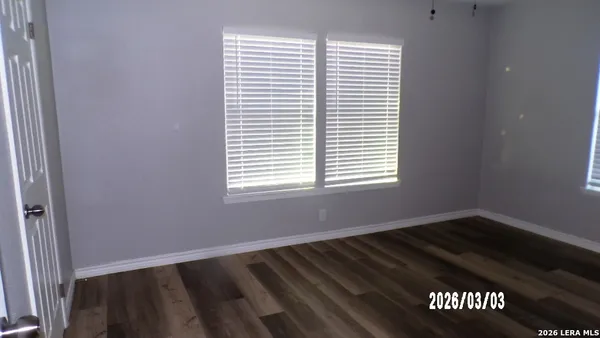 a view of a small space with wooden floor and a window