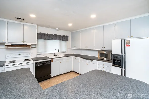 a kitchen with stainless steel appliances granite countertop a refrigerator sink and stove