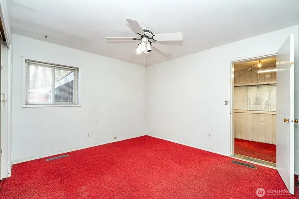a view of empty room with window and ceiling fan