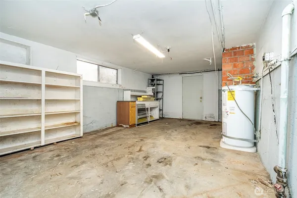 a view of a storage & utility room with refrigerator and more cabinets