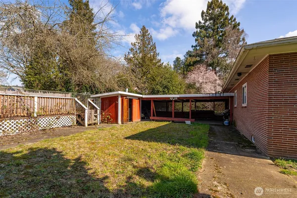 a view of a yard with wooden fence and trees