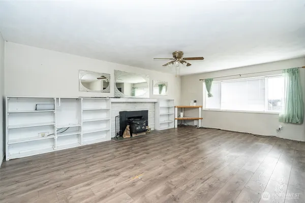 a view of an empty room with a fireplace and a window