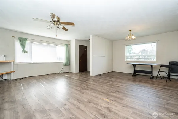 a view of an empty room with a window and wooden floor