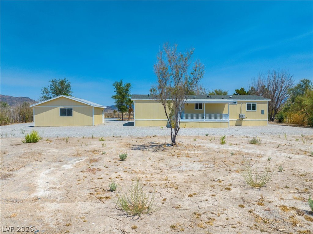 4081 Retread Road Pahrump, NV 89048 - Photo 64 of 98 A desert-landscape property with a charming, sun-colored residence and a detached garage.