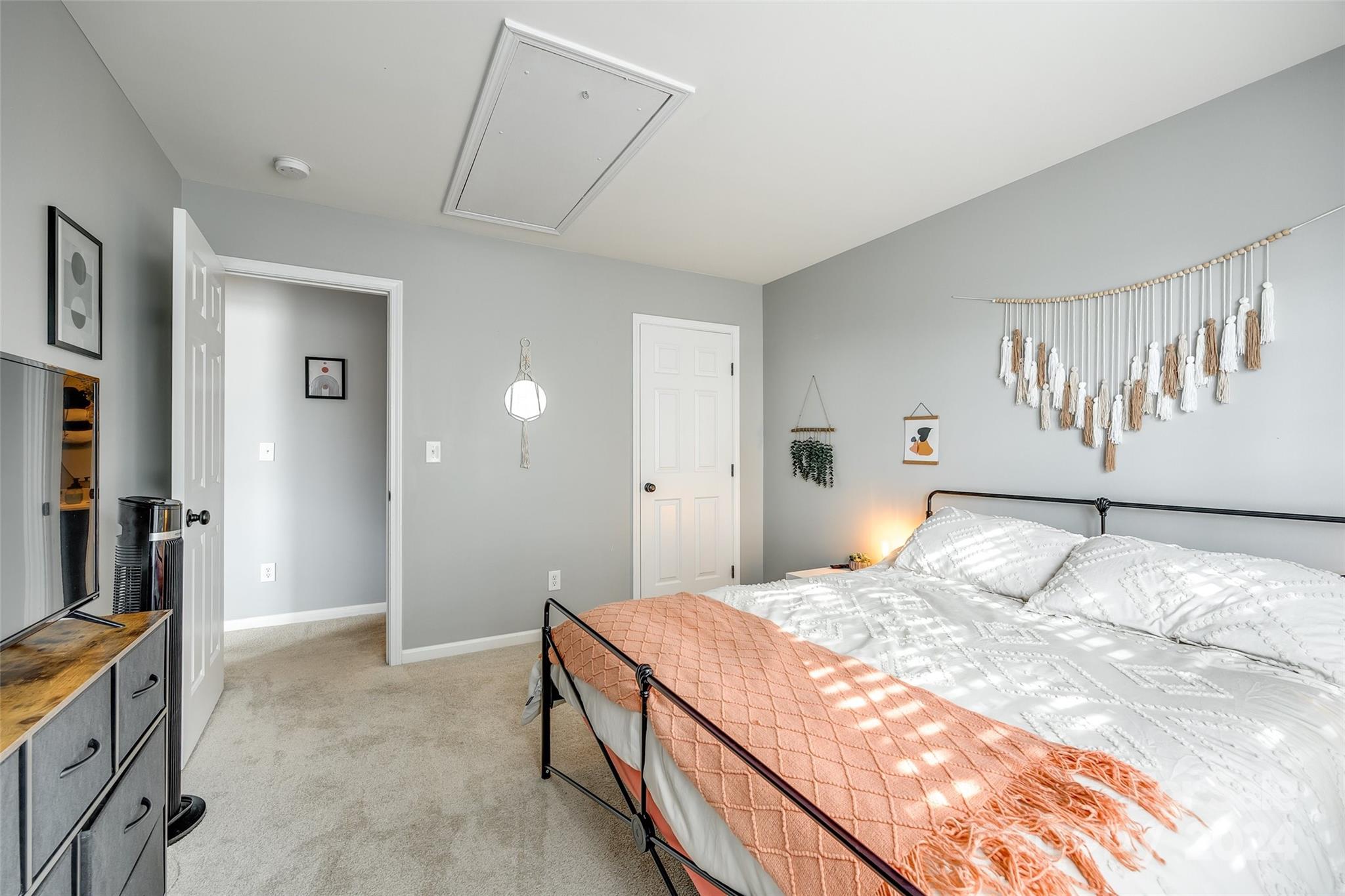 11417 Winget Pond Road Charlotte, NC 28278 - Photo 20 of 39 a bedroom with a large bed and a chandelier