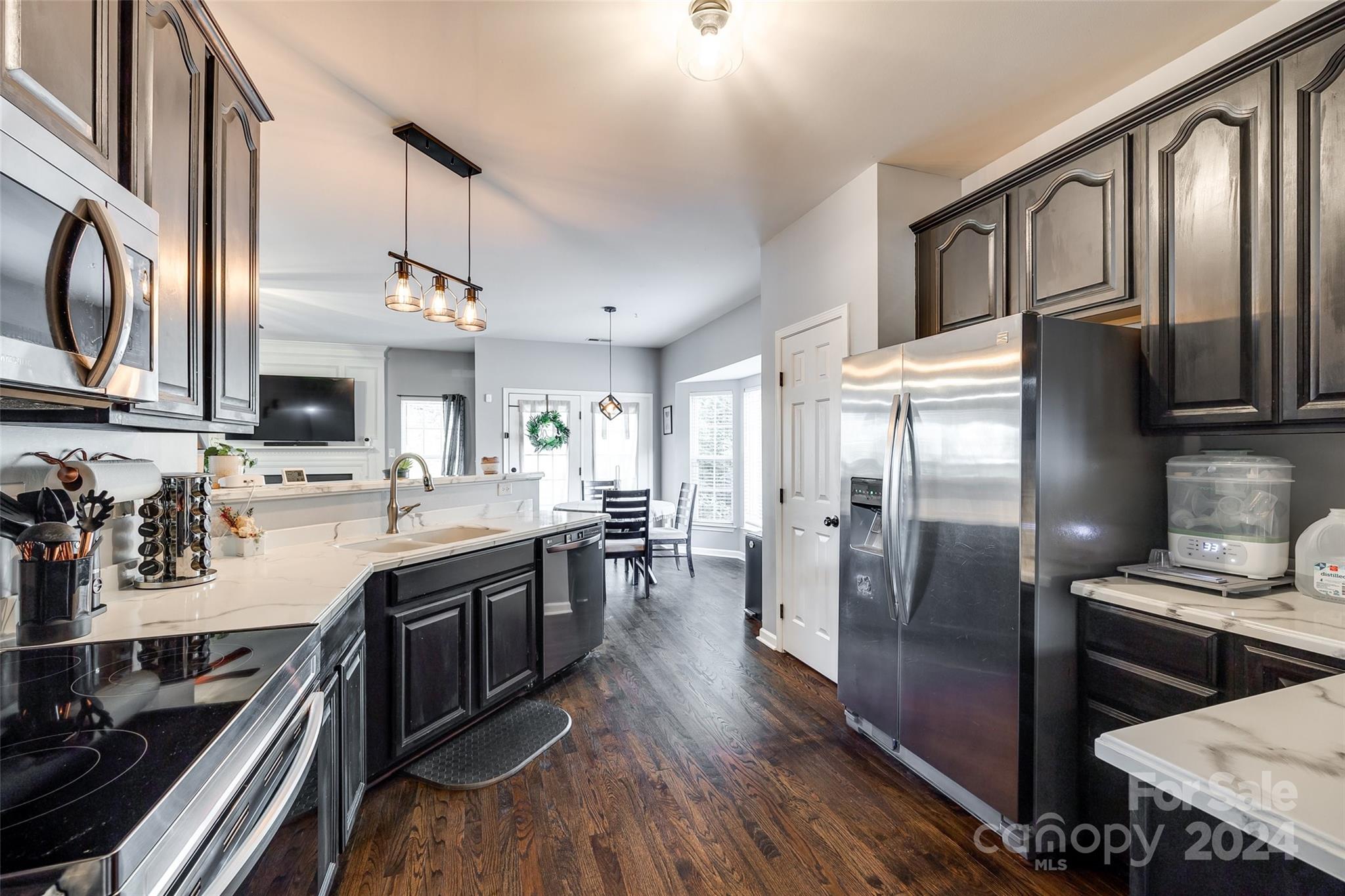 11417 Winget Pond Road Charlotte, NC 28278 - Photo 8 of 39 a kitchen with stainless steel appliances granite countertop a refrigerator a stove top oven a sink dishwasher and wooden cabinets with wooden floor