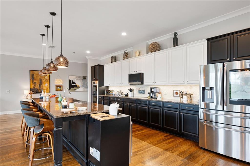 360 Chambers Street, Unit 407 Woodstock, GA 30188 - Photo 2 of 62 a kitchen with stainless steel appliances kitchen island granite countertop a sink refrigerator and cabinets