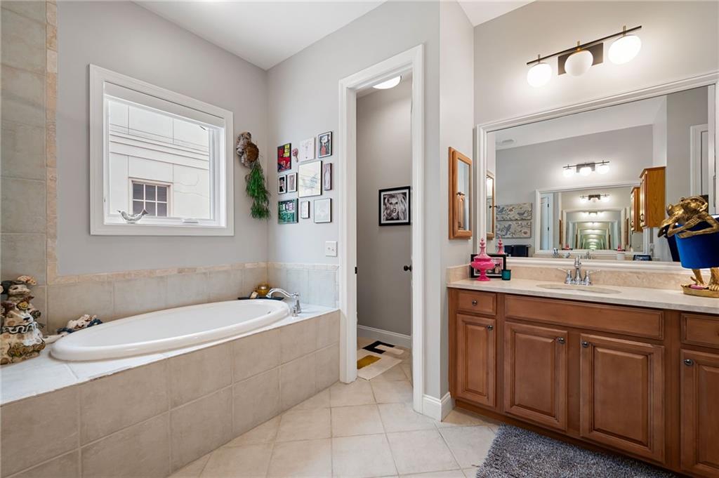 360 Chambers Street, Unit 407 Woodstock, GA 30188 - Photo 34 of 62 a bathroom with a tub a sink and mirror