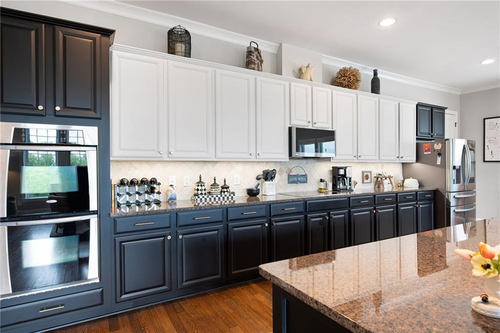 360 Chambers Street, Unit 407 Woodstock, GA 30188 - Photo 5 of 62 a kitchen with granite countertop a stove and cabinets