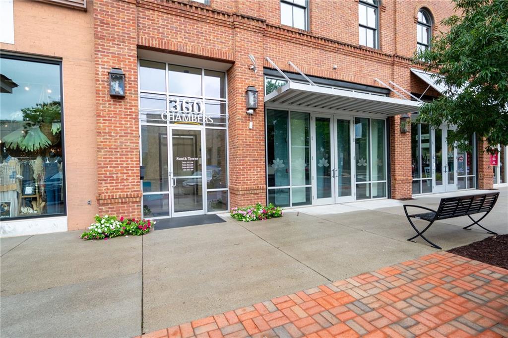 360 Chambers Street, Unit 407 Woodstock, GA 30188 - Photo 52 of 62 front view of a brick buildings with a bench in front of building