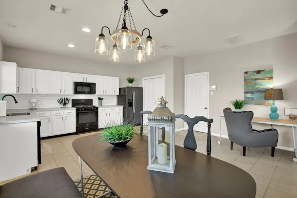 a living room with lots of white furniture and kitchen view