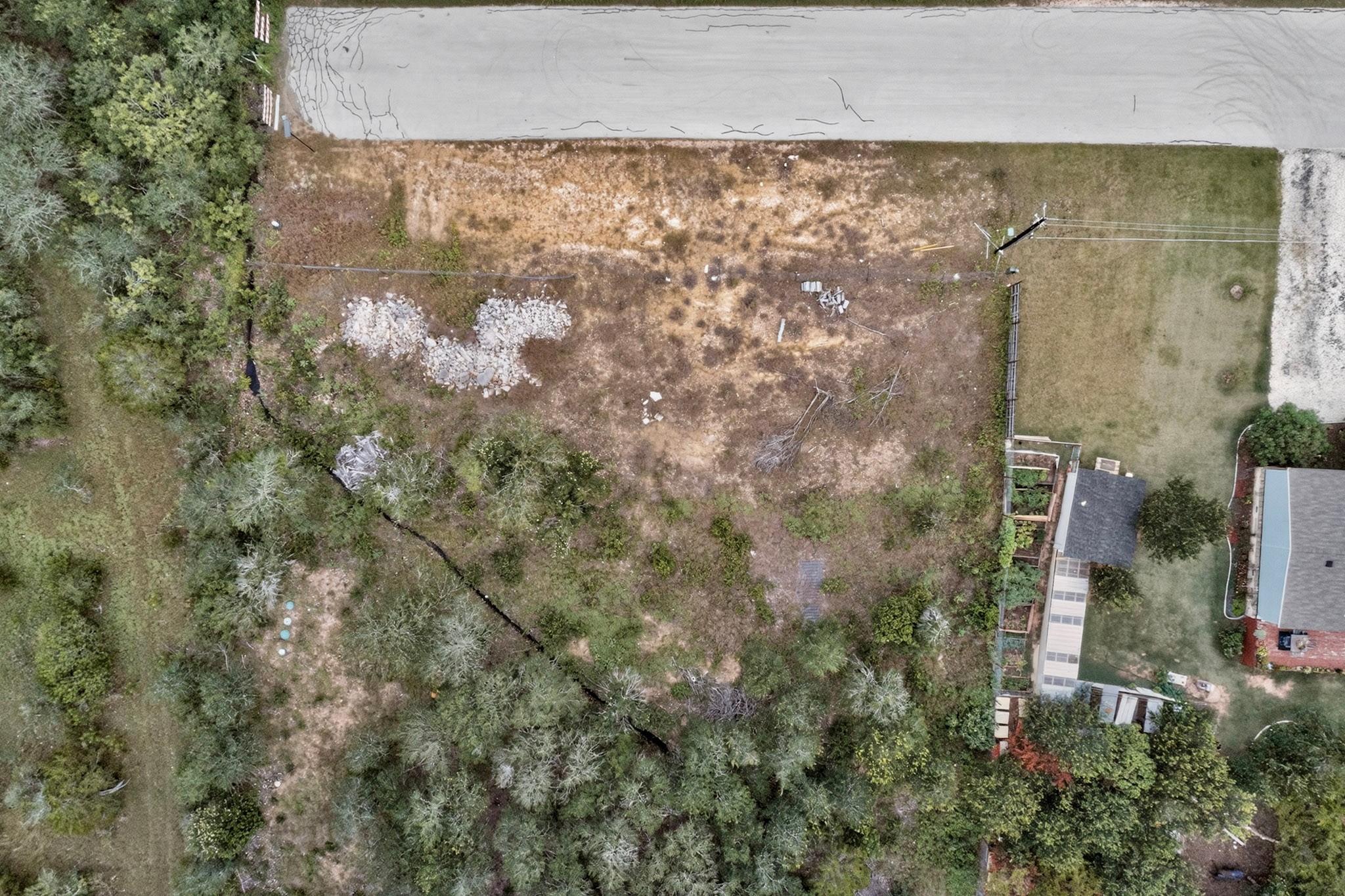 693 Santa Teresa Road Kyle, TX 78640 - Photo 4 of 20 A spacious, buildable lot awaits your vision, bordered by established trees and a paved road.