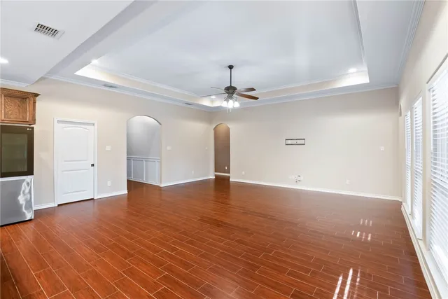 a view of a livingroom with a chandelier fan and wooden floor