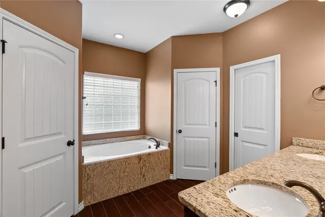 a bathroom with a tub toilet sink and mirror