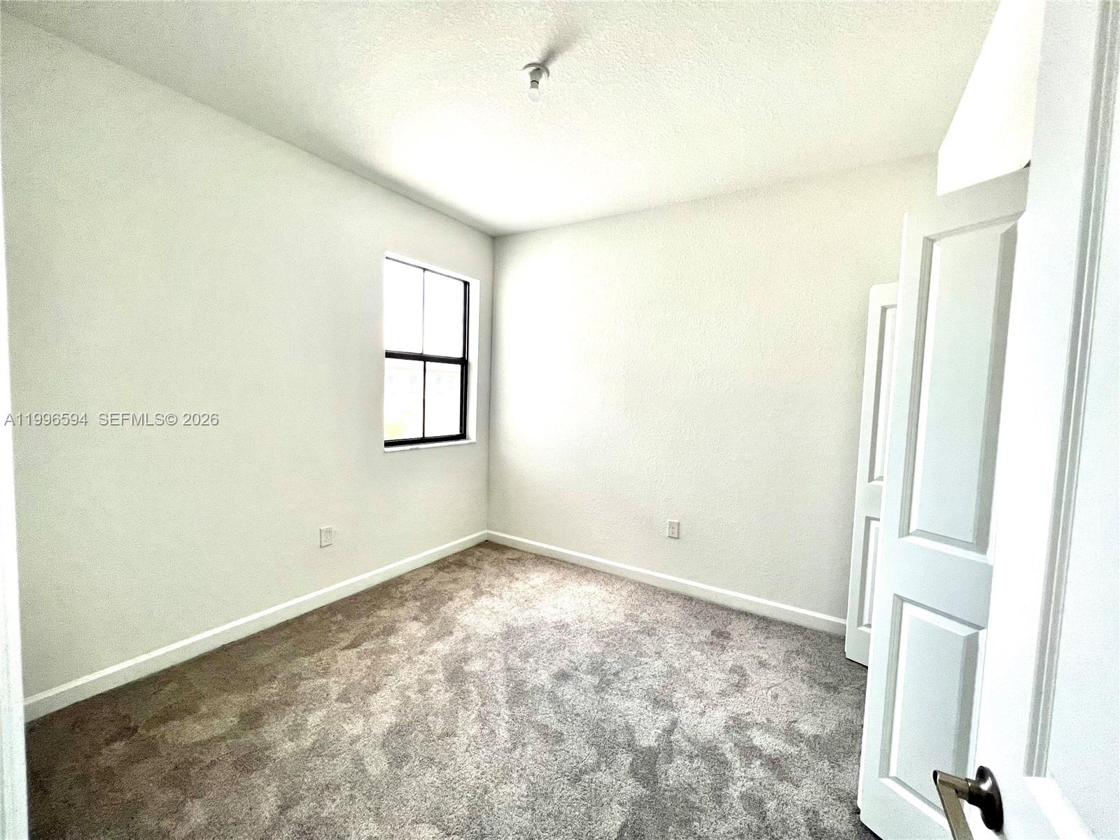 23373 Southwest 129th Path, Unit 23373 Homestead, FL 33032 - Photo 14 of 18 a view of an empty room with a window