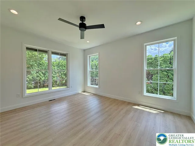 a view of empty room with wooden floor and window