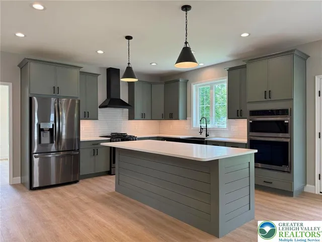 an empty room with windows fireplace and wooden floor