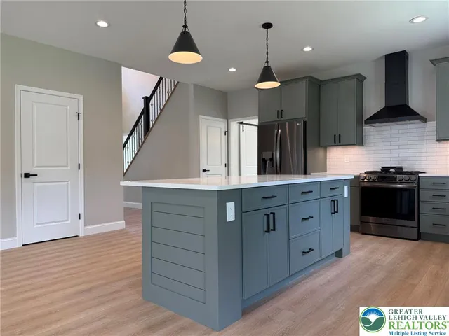 an empty room with windows fireplace and wooden floor