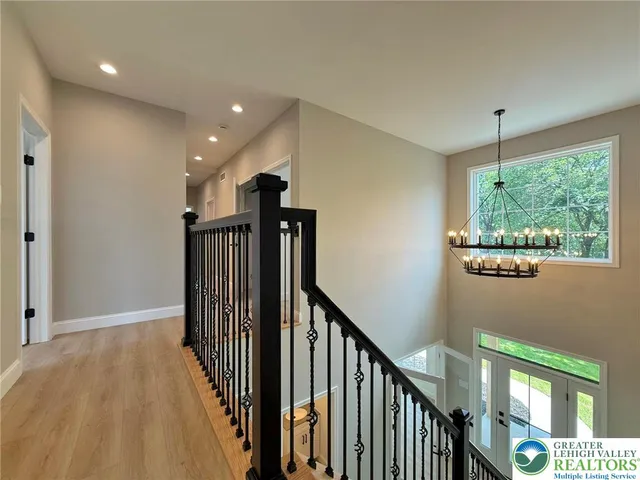 an empty room with wooden floor ceiling fan and windows