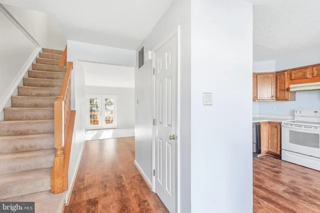 a view of a hallway with wooden floor and entryway