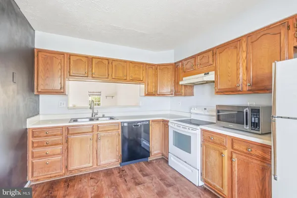a kitchen with stainless steel appliances granite countertop a sink stove and cabinets