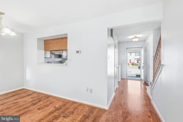 a view of a hallway with wooden floor and a bathroom