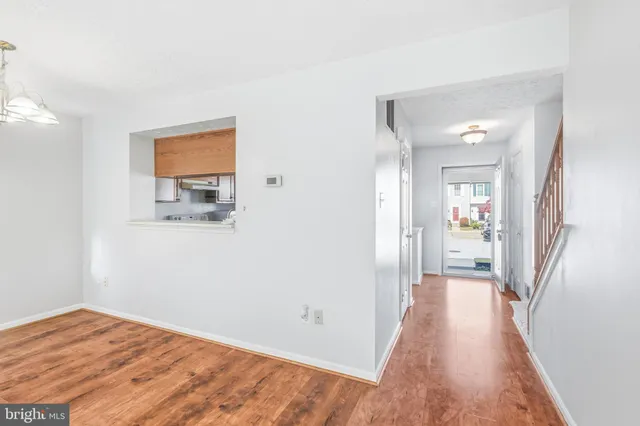 a view of a hallway with wooden floor and a bathroom