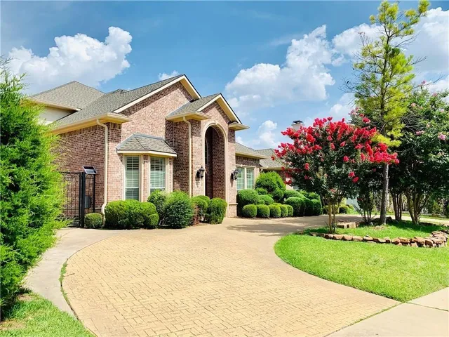a front view of a house with a yard and a garden