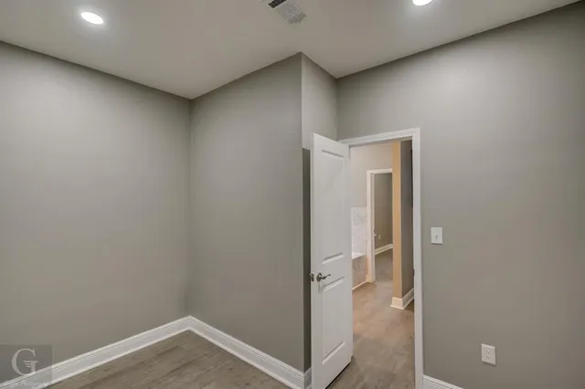 an empty room with closet and a ceiling fan