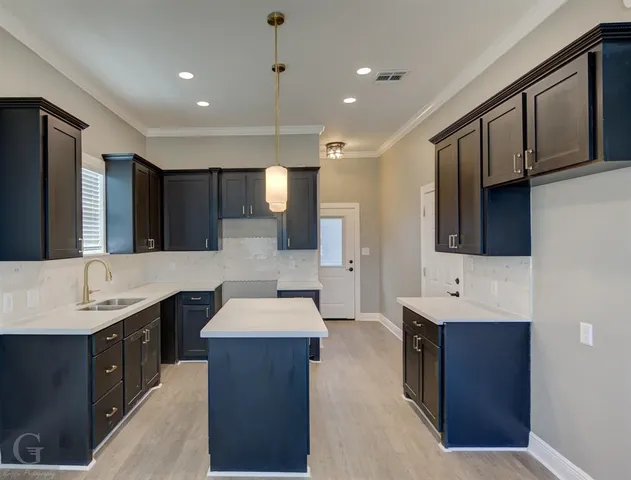 a large kitchen with stainless steel appliances granite countertop a sink stove and refrigerator