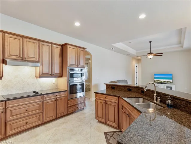 a kitchen with granite countertop a stove oven and sink