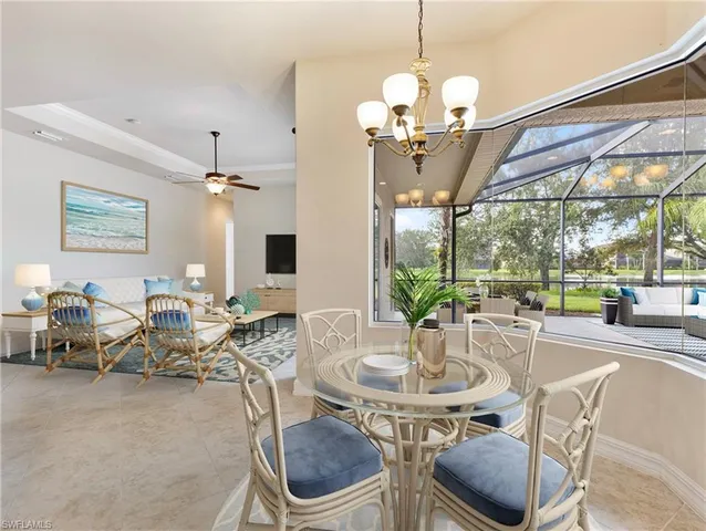 a view of a dining room with furniture a chandelier and large windows