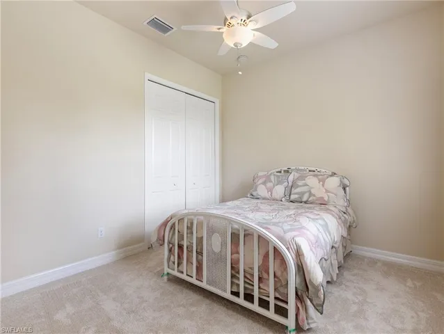 a bedroom with a bed and a chandelier fan