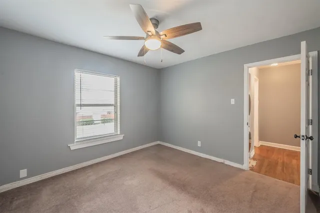 an empty room with closet and windows