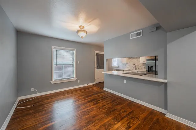 a kitchen with stainless steel appliances granite countertop a sink cabinets and wooden floor