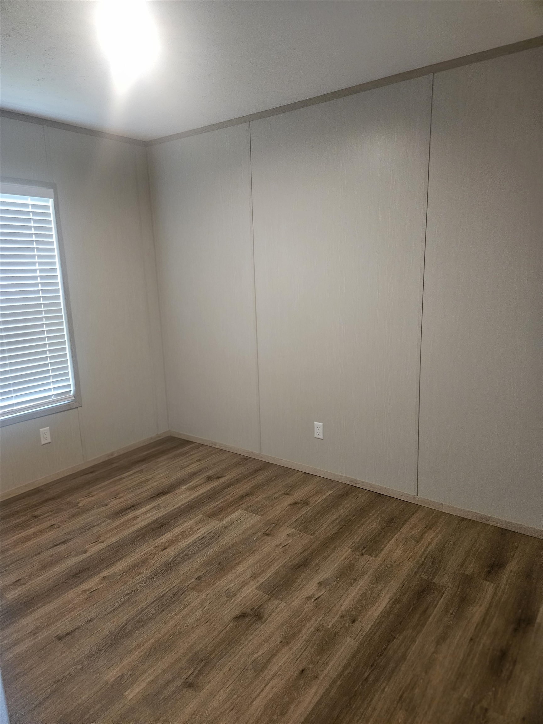75 Pittman Road, Unit ROAD Somerville, TN 38068 - Photo 19 of 26 Room featuring wood-finish flooring, light-toned walls with paneling, baseboard trim, and a window with blinds