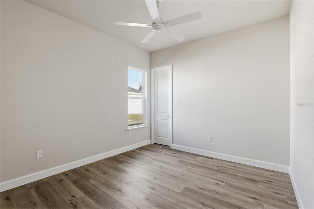 13425 Southwest 9th Road Newberry, FL 32669 - Photo 28 of 46 an empty room with wooden floor and fan
