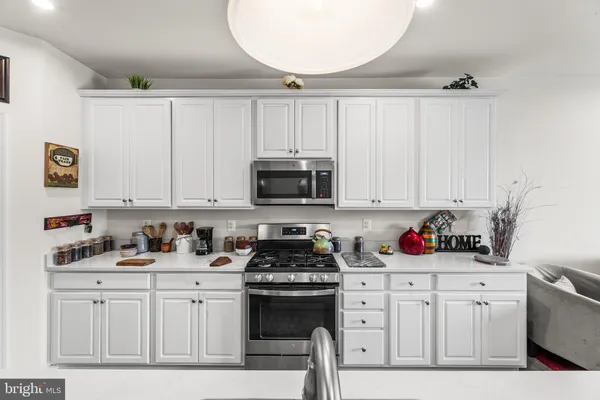 a kitchen with white cabinets and black appliances