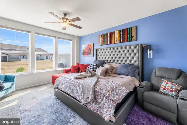 a bedroom with a bed couch and a large window