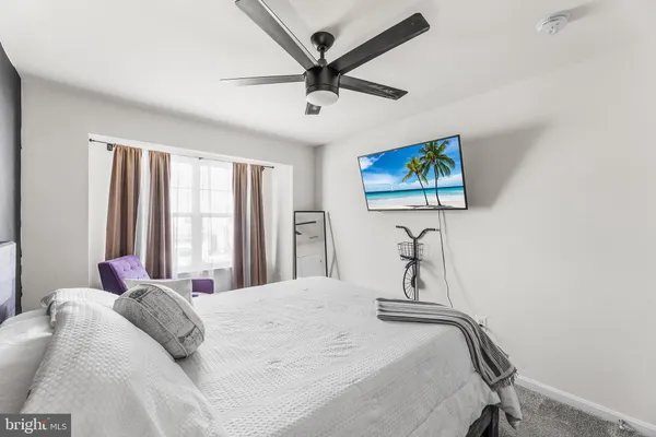 a bedroom with a bed a window and a chandelier