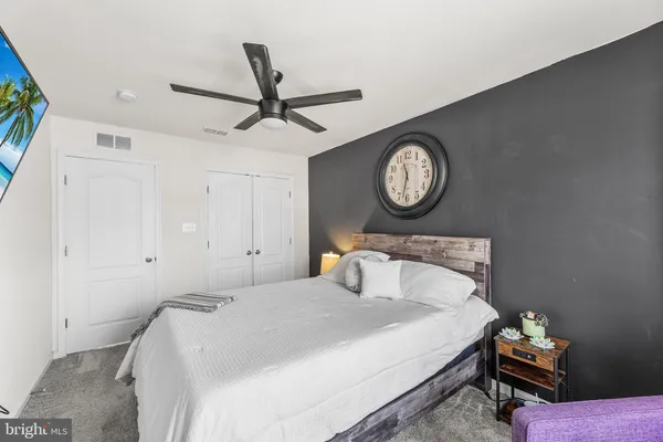 a bedroom with a bed and a clock on the wall