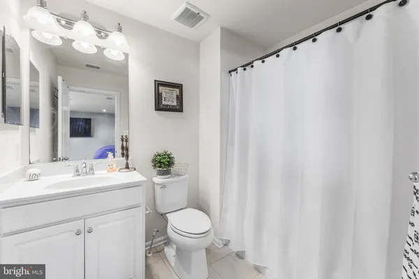 a bathroom with a sink vanity mirror and toilet