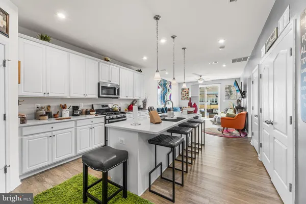 a kitchen with stainless steel appliances granite countertop a table chairs sink and cabinets