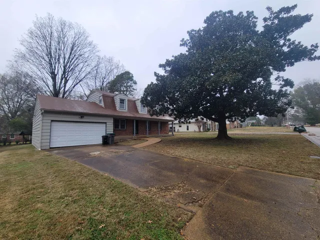 a view of a house with a yard and garage