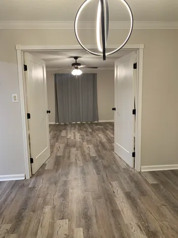 a view of a livingroom with wooden floor and a bathroom