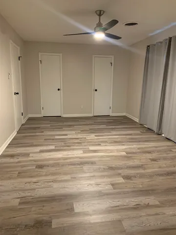 a view of empty room with window and ceiling fan