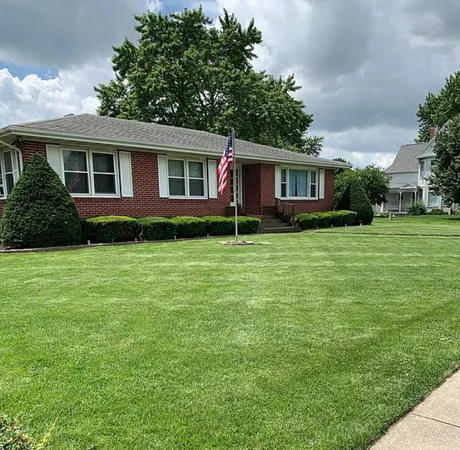 a front view of a house with a garden and plants