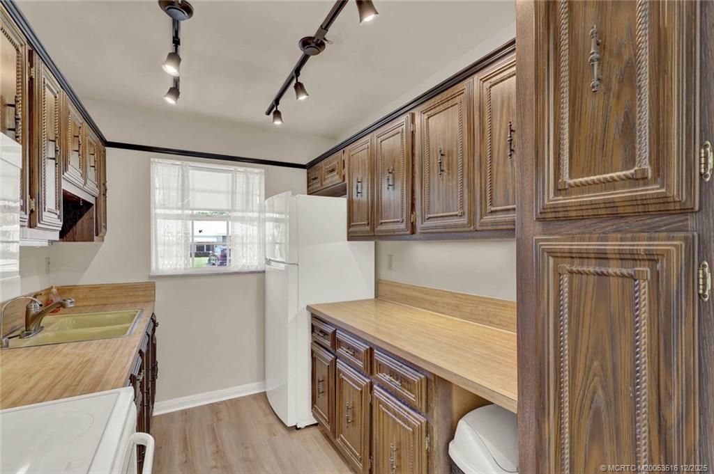 902 Savannas Point Drive, Unit D Fort Pierce, FL 34982 - Photo 11 of 44 a kitchen with stainless steel appliances granite countertop a refrigerator a stove and a wooden cabinets