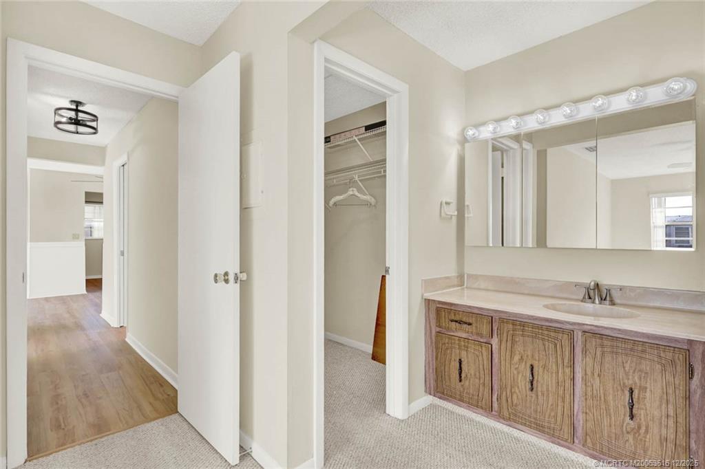 902 Savannas Point Drive, Unit D Fort Pierce, FL 34982 - Photo 19 of 44 a spacious bathroom with a double vanity sink and a mirror
